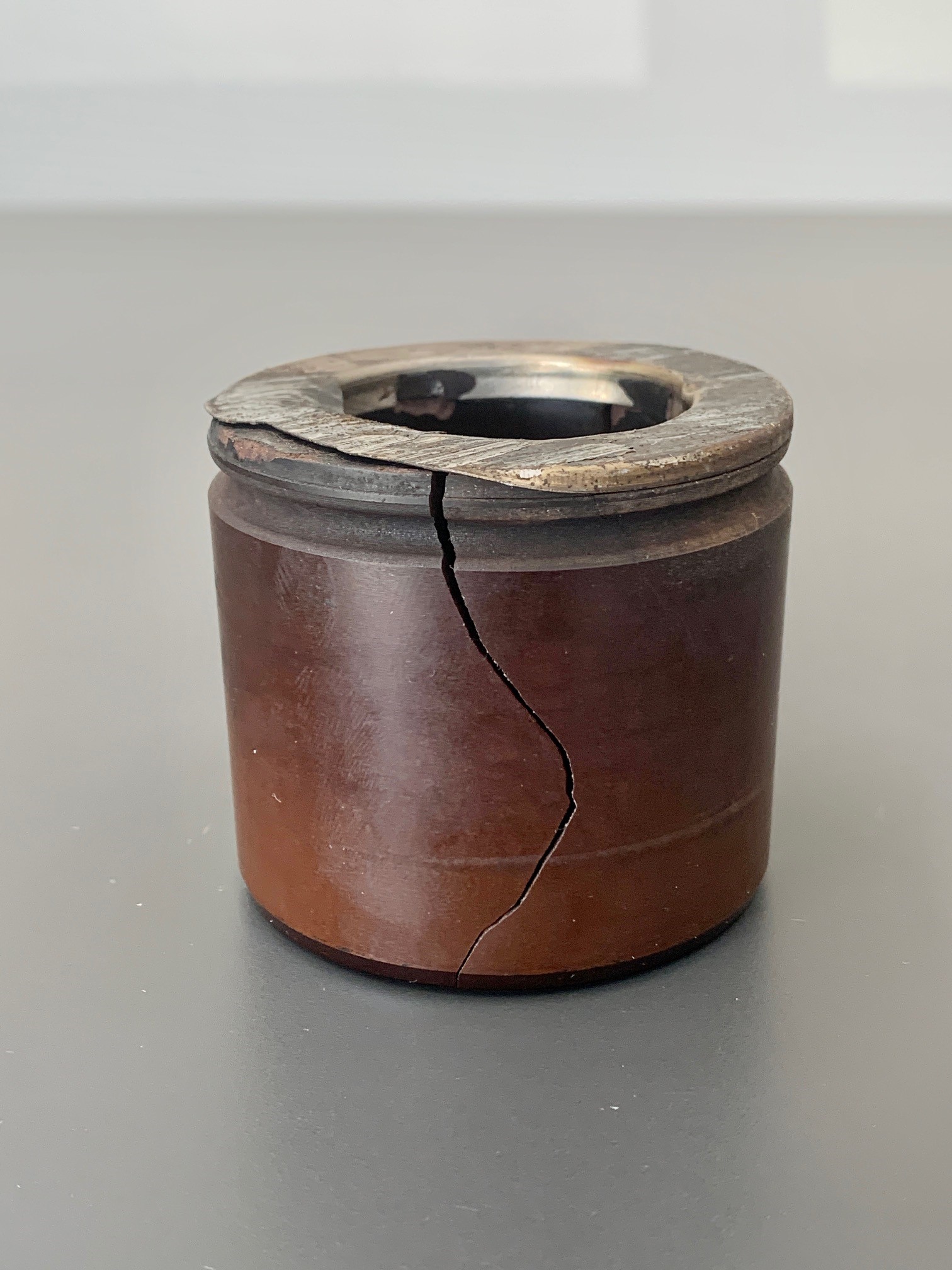Photo of a cracked and damaged phenolic disk brake caliper piston due to swelling