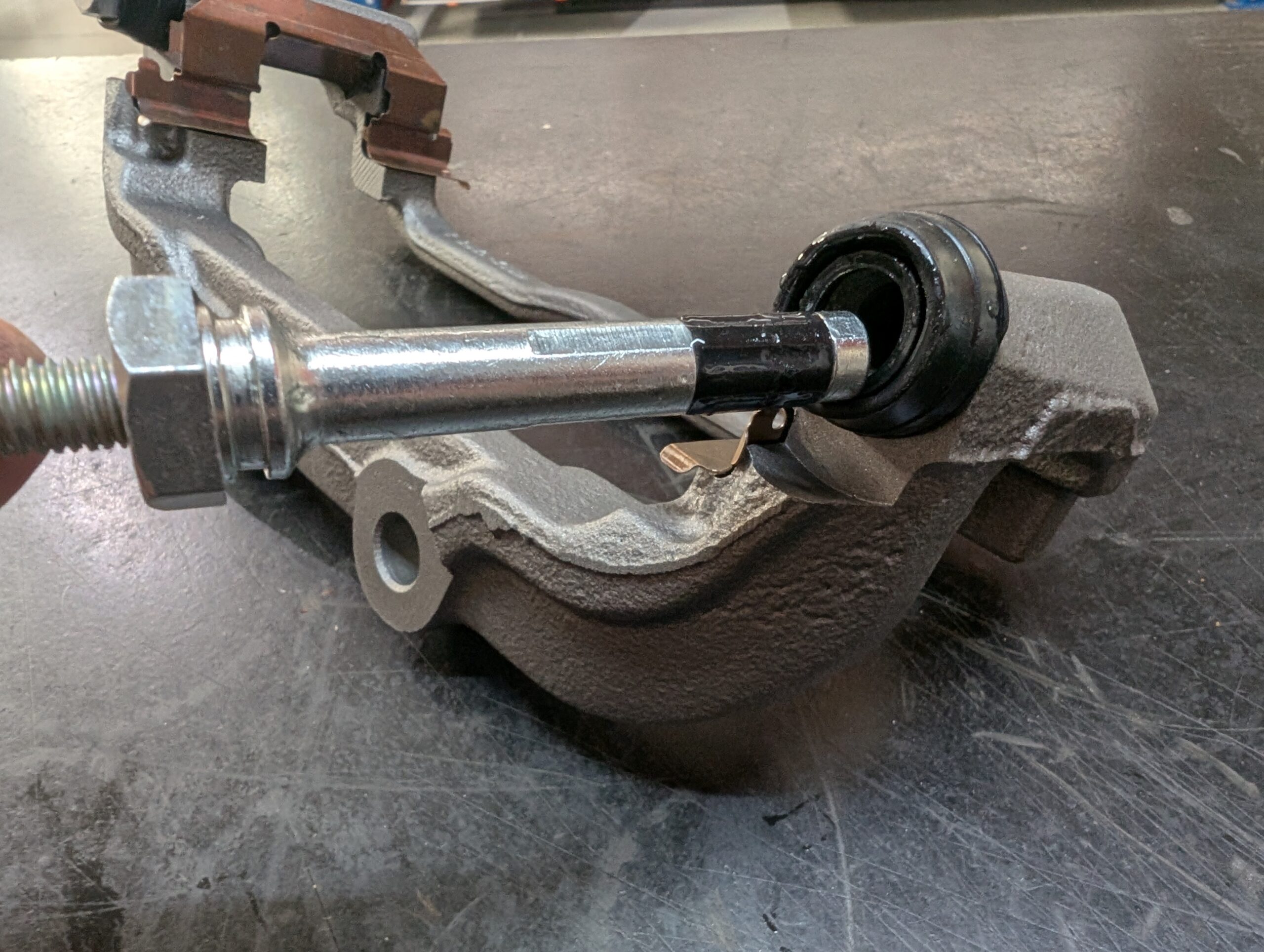 A remanufactured floating caliper bracket with new caliper guide pins with added sleeves.